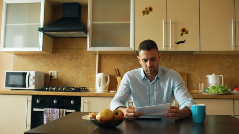 Person reviewing tax forms, receipts, and a calculator at a well-organized home desk.