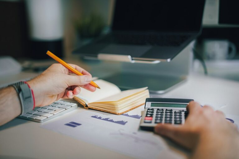 Small business owner and accountant reviewing receipts, invoices, and financial statements at a desk.